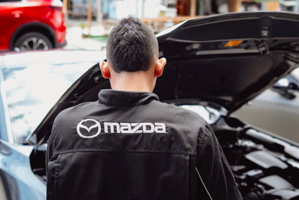 Mecánico Mazda revisando motor