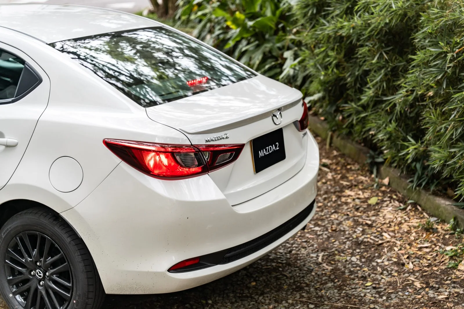 Mazda 2 Sedán vista trasera en jardín