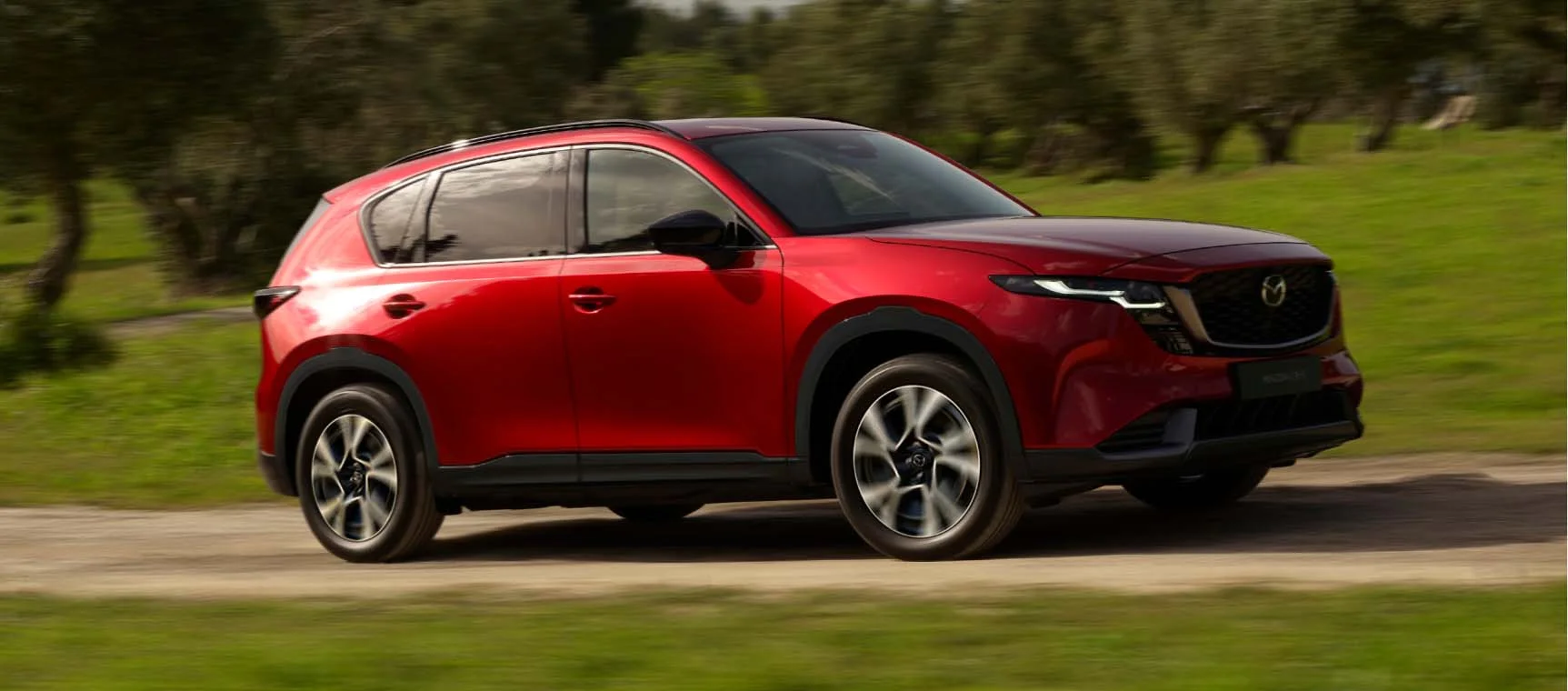Nueva Mazda CX-5 roja en movimiento por una carretera rural