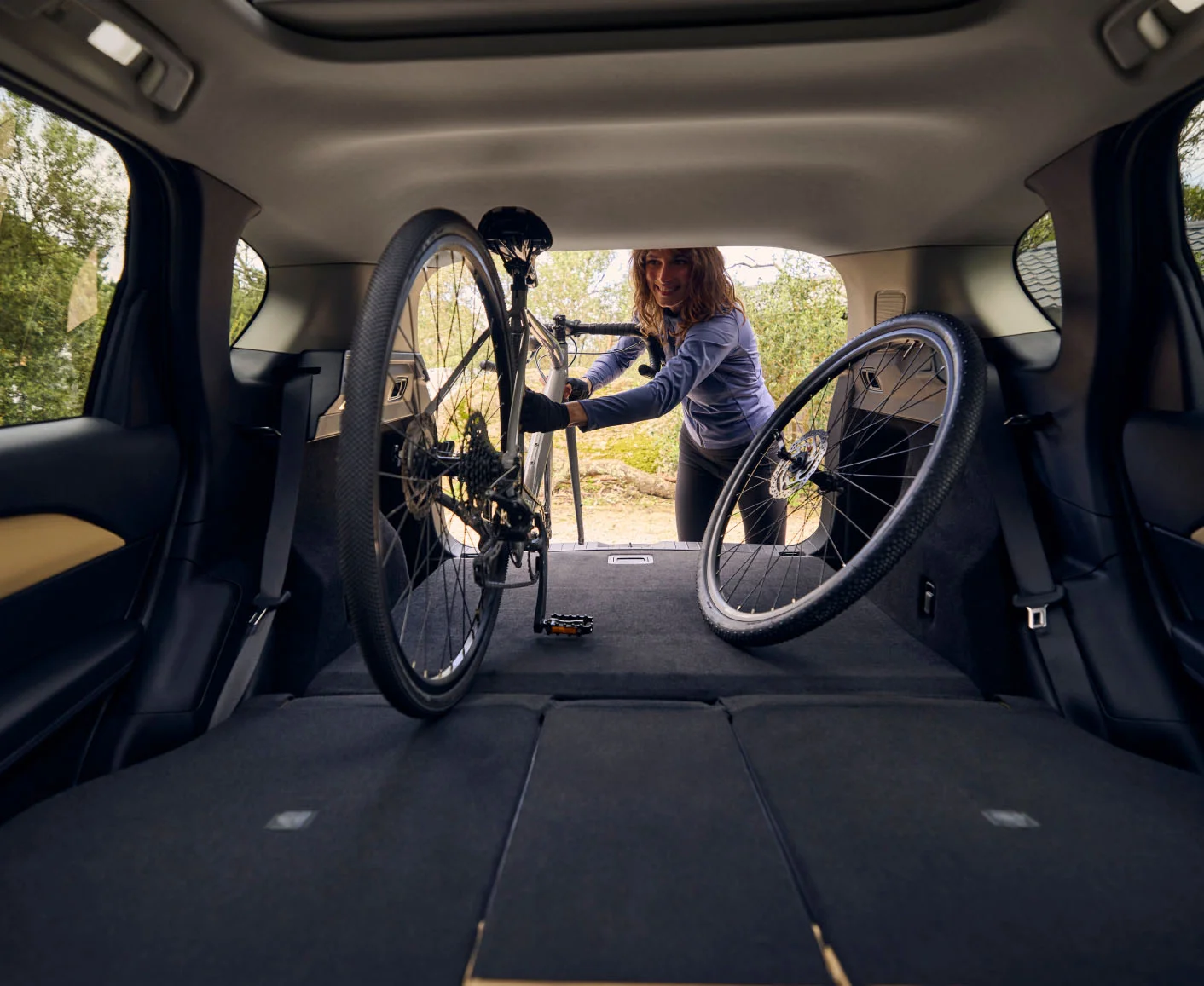 Mujer bajando una bicicleta del baúl de la nueva Mazda CX-5